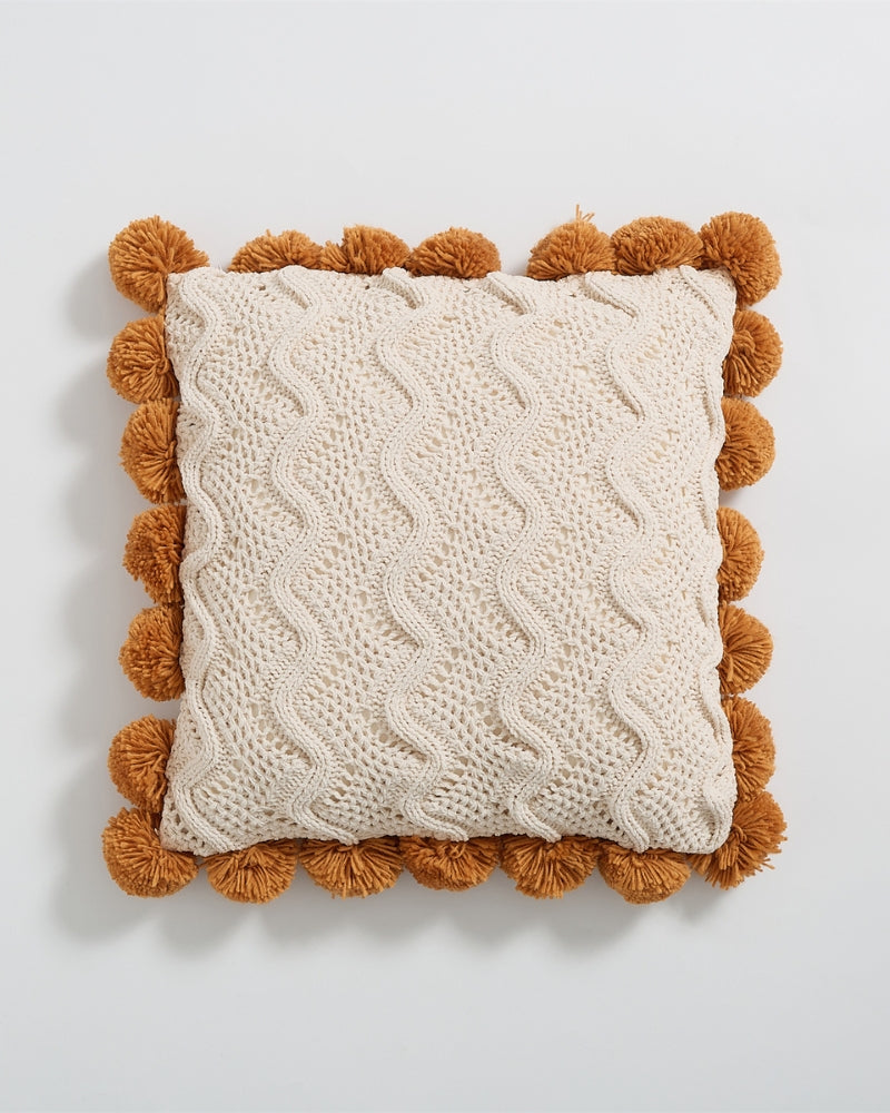 Coussin crème et caramel sur un canapé moderne