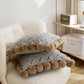 Gros plan sur pompons marron du coussin gris