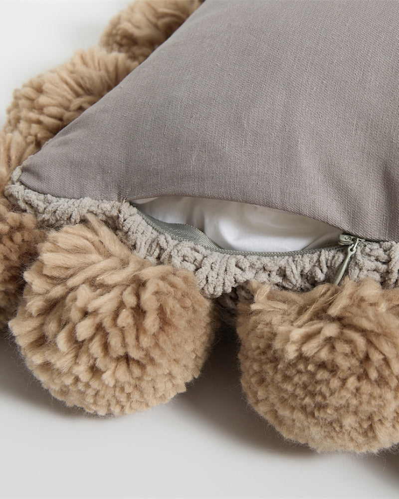 Coussin gris et marron sur lit blanc