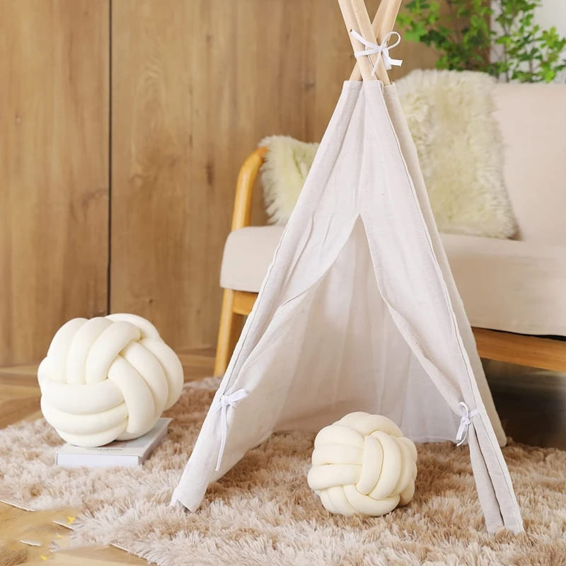 Coussin noué en velours posé sur un canapé