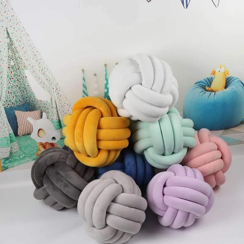 Coussin noué en velours sur un lit d'enfant
