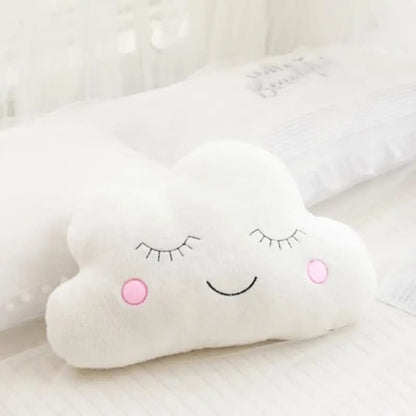 Coussin nuage moelleux pour bébé posé sur un lit rose