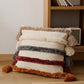Coussin bohème avec pompons et matière pelucheuse