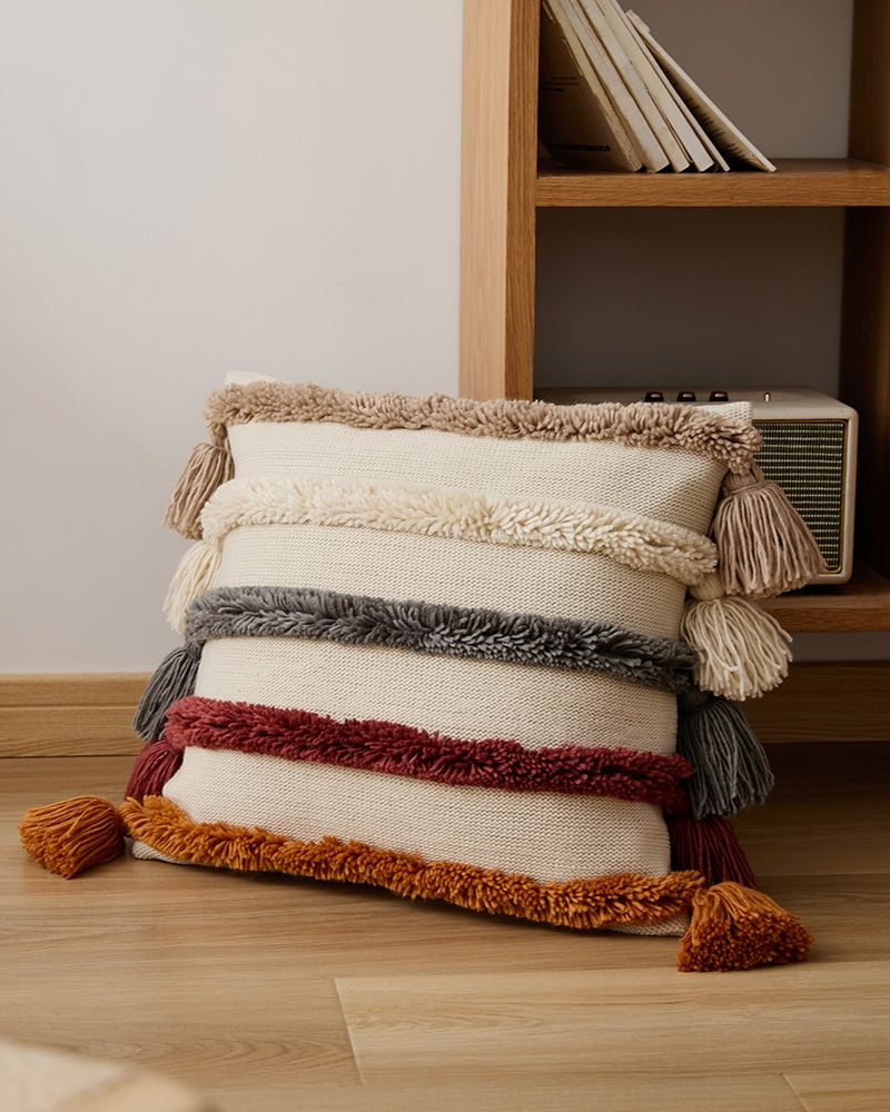 Coussin bohème avec pompons et matière pelucheuse