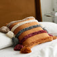 Détail d'un coussin en peluche avec pompons multicolores