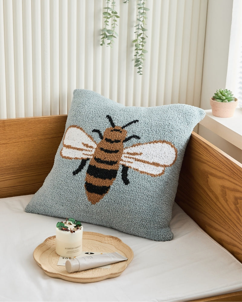 Coussin bleu ciel avec motif abeille en gros plan
