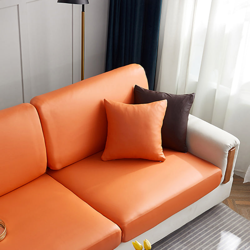 Housse de coussin en simili cuir beige sur canapé gris
