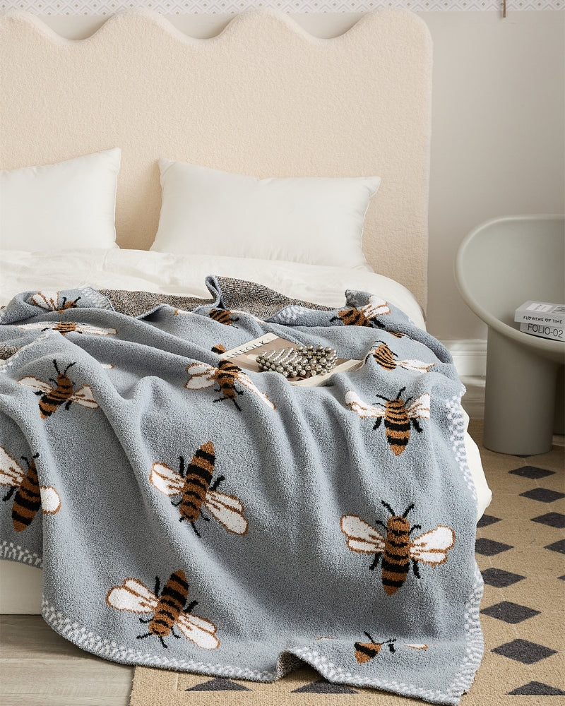 Couverture bleu gris avec motifs d'abeilles en gros plan
