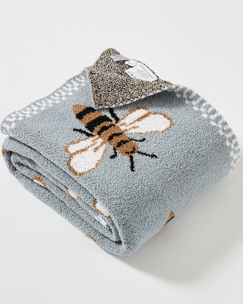 Couverture étalée sur un lit, motifs visibles