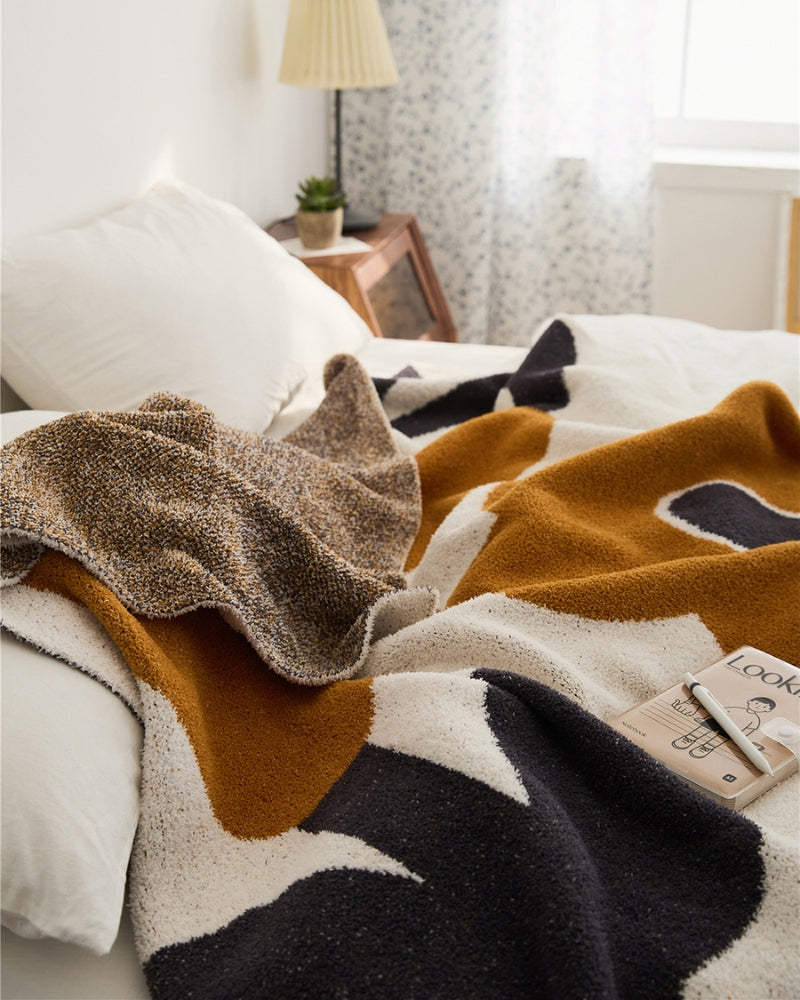 Couverture en fausse fourrure avec motif floral noir et orange