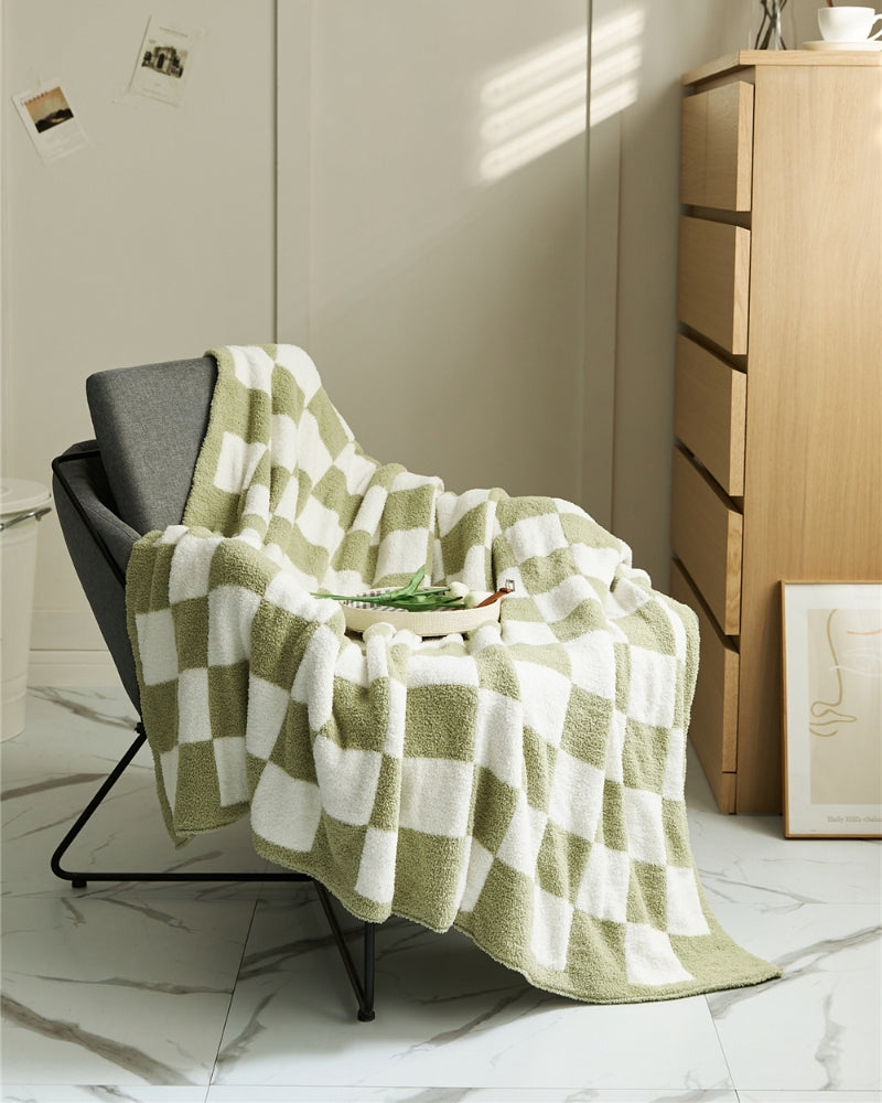 Couverture à carreaux marron et blanc pliée sur un lit