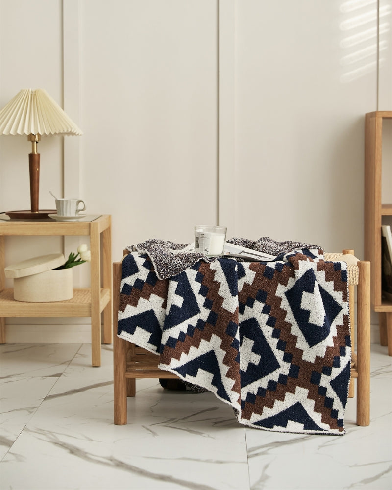 Couverture moumoute à motifs ethniques sur canapé beige