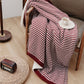 Couverture peluche bordeaux à carreaux sur canapé
