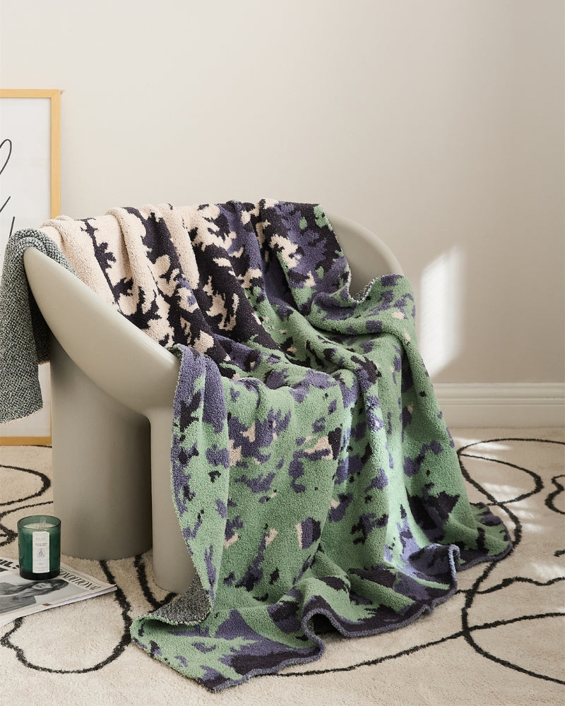 Couverture polaire avec motif forêt colorée sur un lit