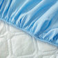 Drap housse bleu ciel plié sur une surface