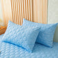 Drap housse bleu ciel en cours d'installation