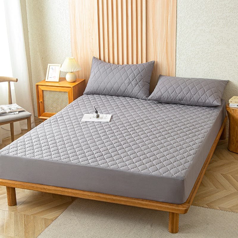 Drap housse gris imperméable sur un lit, vue de côté