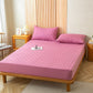 Drap housse rose imperméable sur un lit, vue de côté