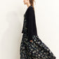 Gilet noir porté avec une robe à motifs