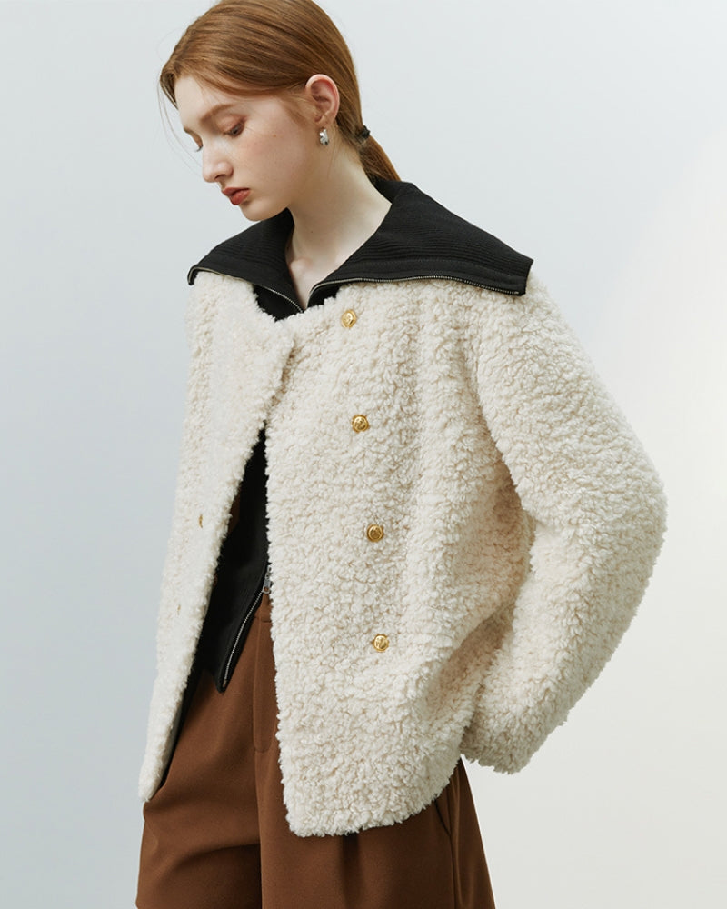 Détail des boutons dorés sur gilet crème molleton