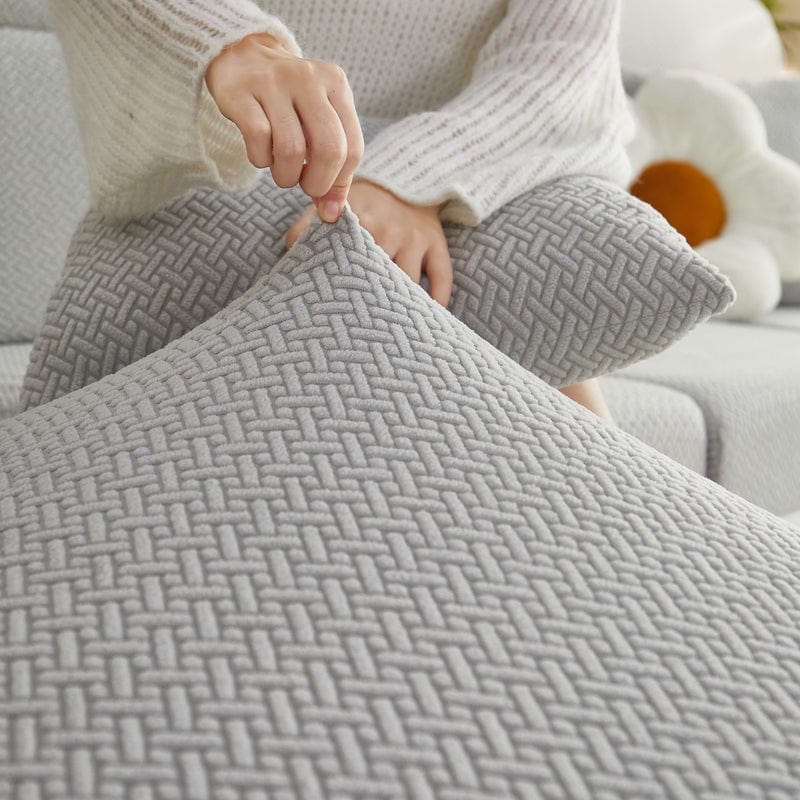 Housse polaire grise sur coussin, texture laine visible