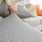 Housse polaire grise sur coussin de canapé, texture moelleuse