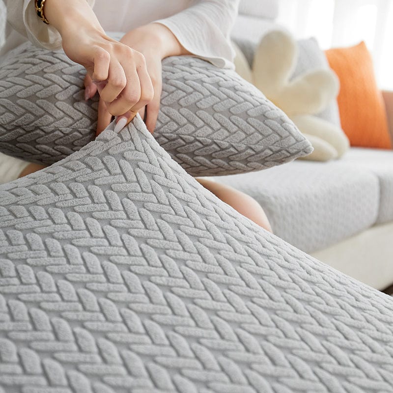 Housse polaire grise sur coussin de canapé, texture moelleuse