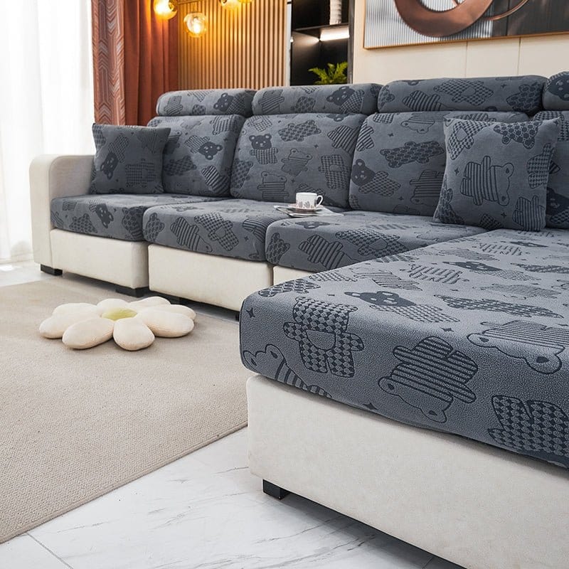 Housse polaire grise ajustée sur coussin, motif ours visible