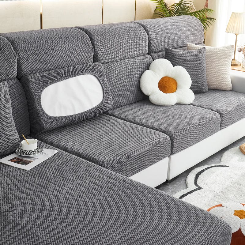 Housse polaire grise couvrant un coussin, motif laine