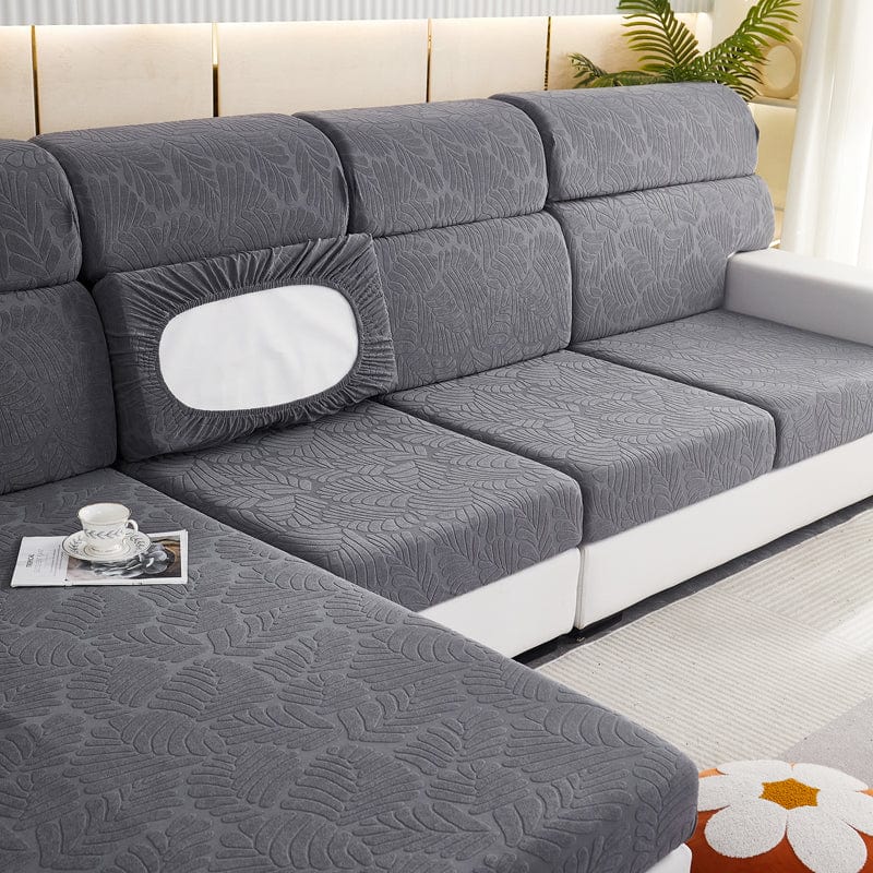 Housse extensible grise couvrant un coussin de canapé