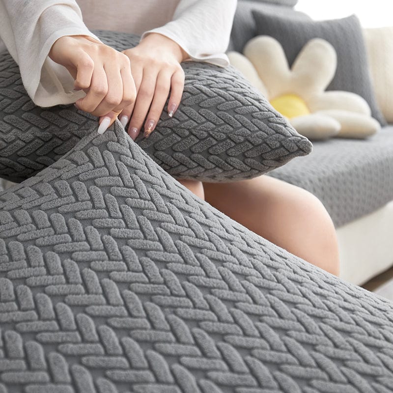 Housse polaire grise sur coussin de canapé, texture moelleuse