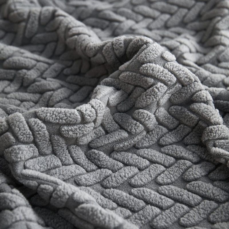 Détail de la texture polaire grise sur un coussin de canapé