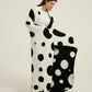 Plaid polaire réversible noir et blanc à pois sur canapé