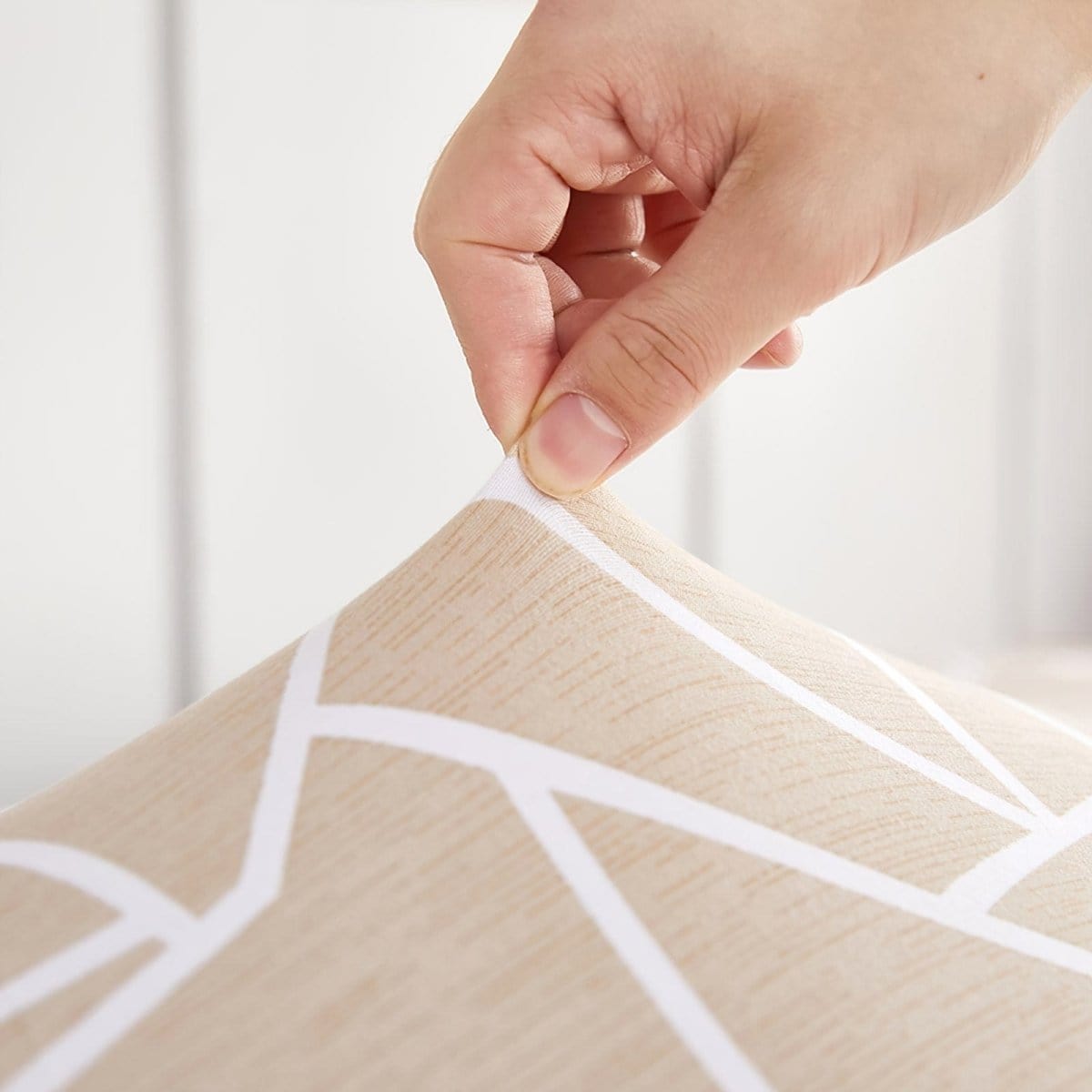 Housse beige couvrant un canapé d'angle dans un intérieur lumineux