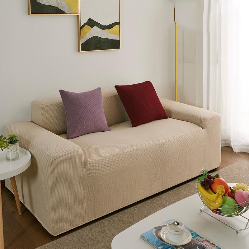 Vue d'ensemble d'un salon avec canapé recouvert de housse beige