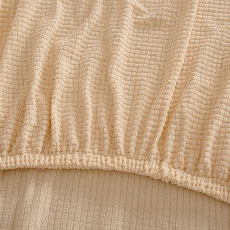 Housse beige couvrant un canapé, protection contre les griffes