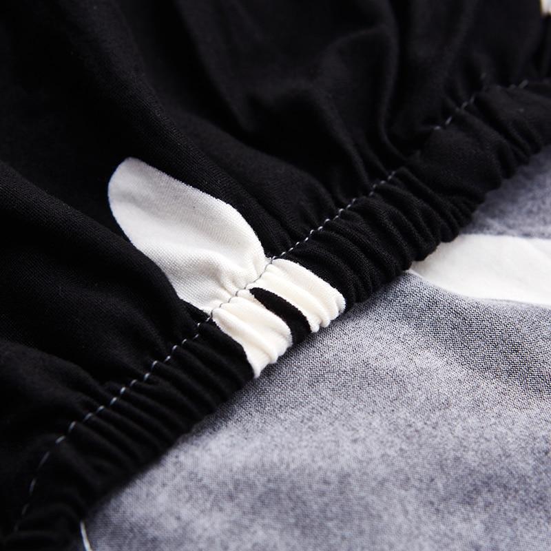 Housse extensible noire couvrant un canapé d'angle