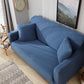 Housse extensible bleue ajustée sur un canapé d'angle