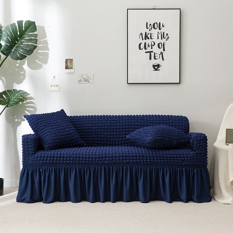 Housse extensible bleue installée sur un canapé panoramique