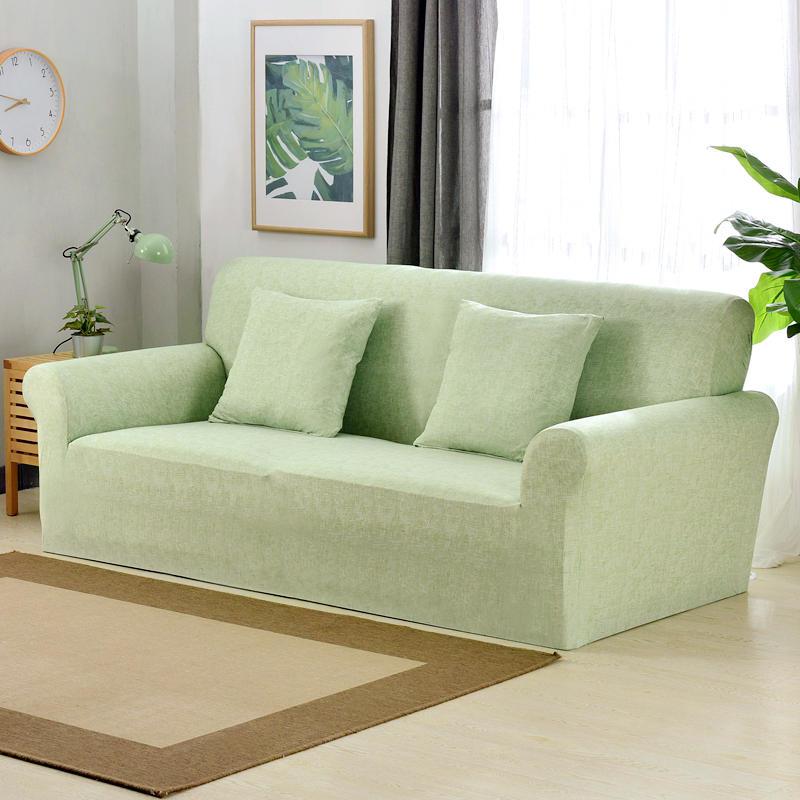 Housse de canapé verte extensible sur un canapé droit