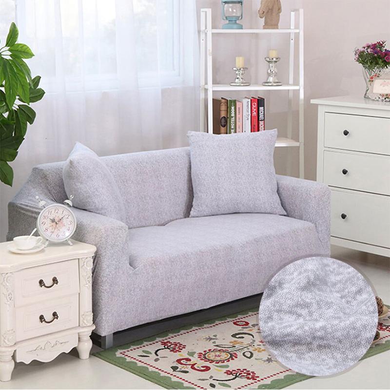 Housse extensible grise sur canapé droit dans un salon moderne
