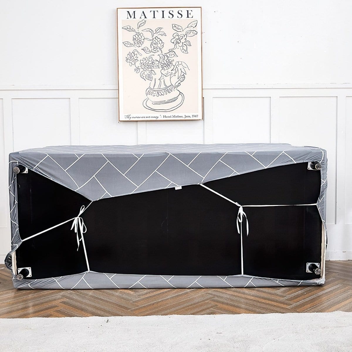 Housse extensible grise couvrant un canapé panoramique