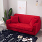 Housse extensible rouge couvrant un canapé d'angle