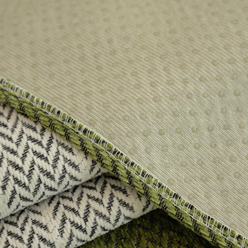 Détail du motif chevron élégant sur une housse de canapé verte