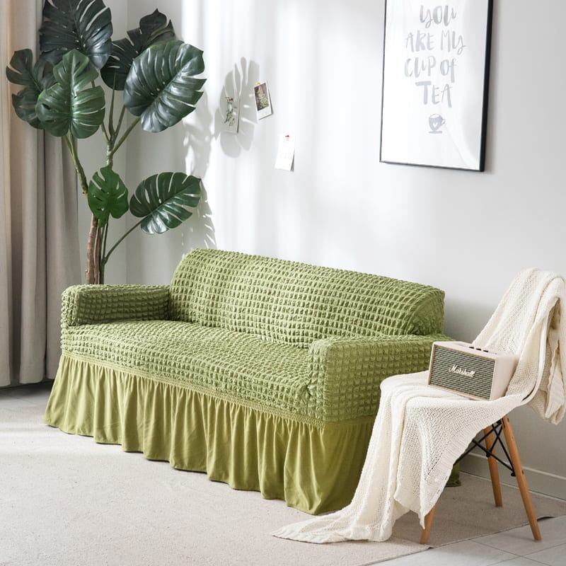 Housse de canapé verte extensible sur un canapé droit