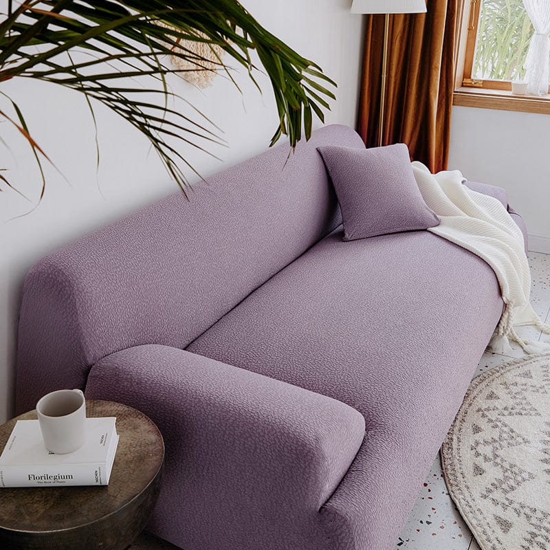 Vue latérale d'une housse de canapé violette, extensible et ajustée