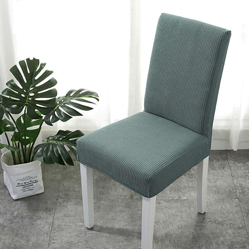 Housse de chaise verte installée sur une chaise standard