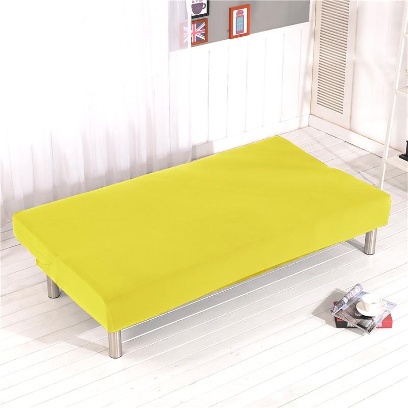 Housse extensible jaune couvrant un canapé-lit déplié