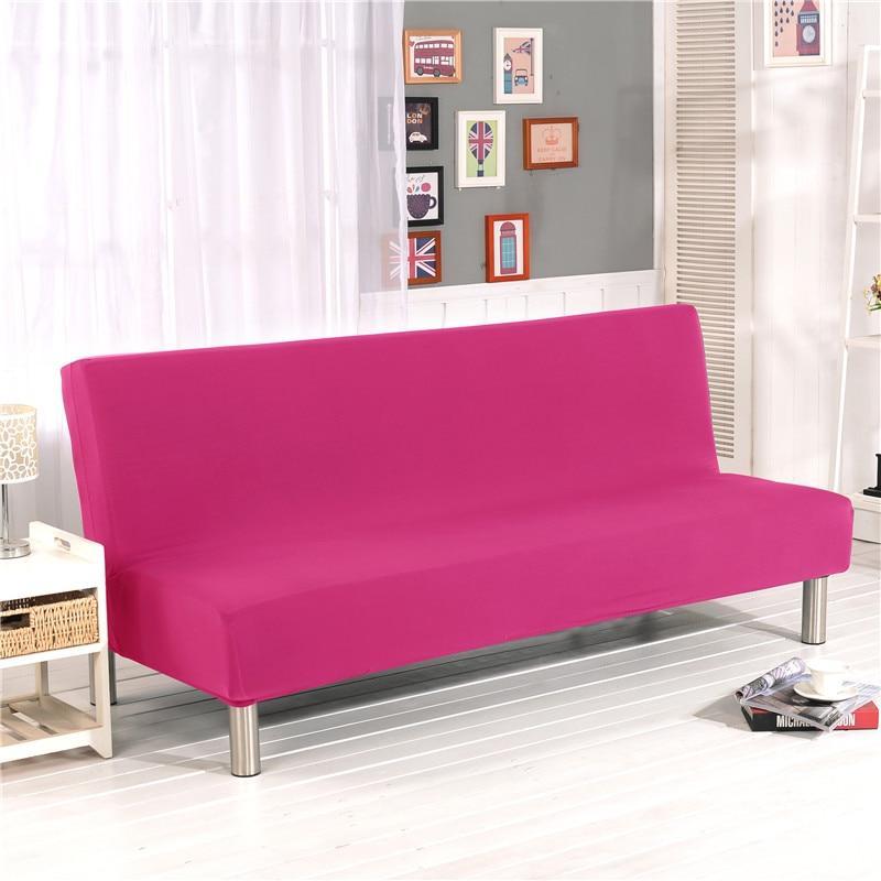 Housse rose couvrant un canapé-lit avec coussins assortis