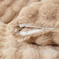 Housse de coussin beige en fausse fourrure sur canapé